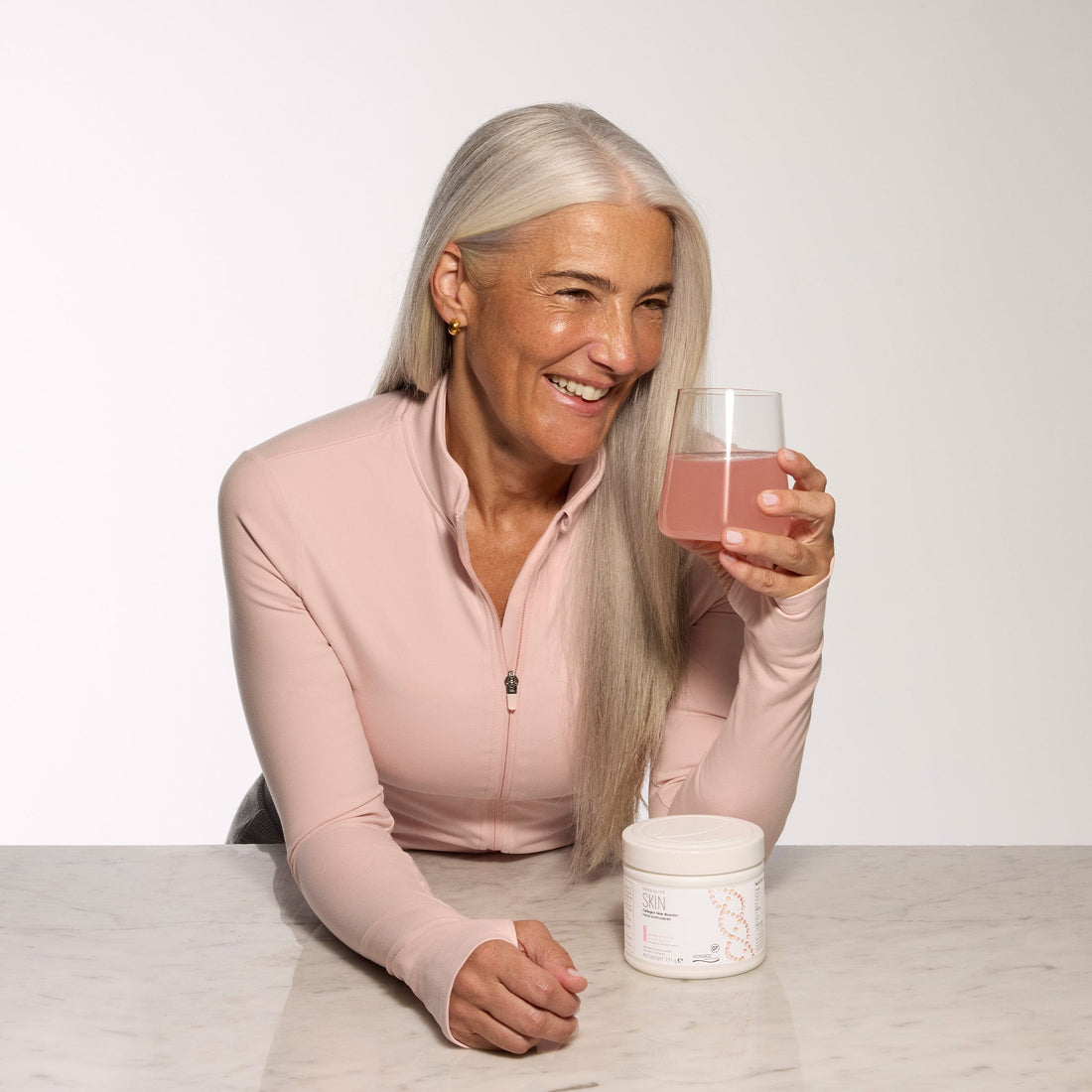 Woman drinking a glass of Herbalife Collagen Skin Booster