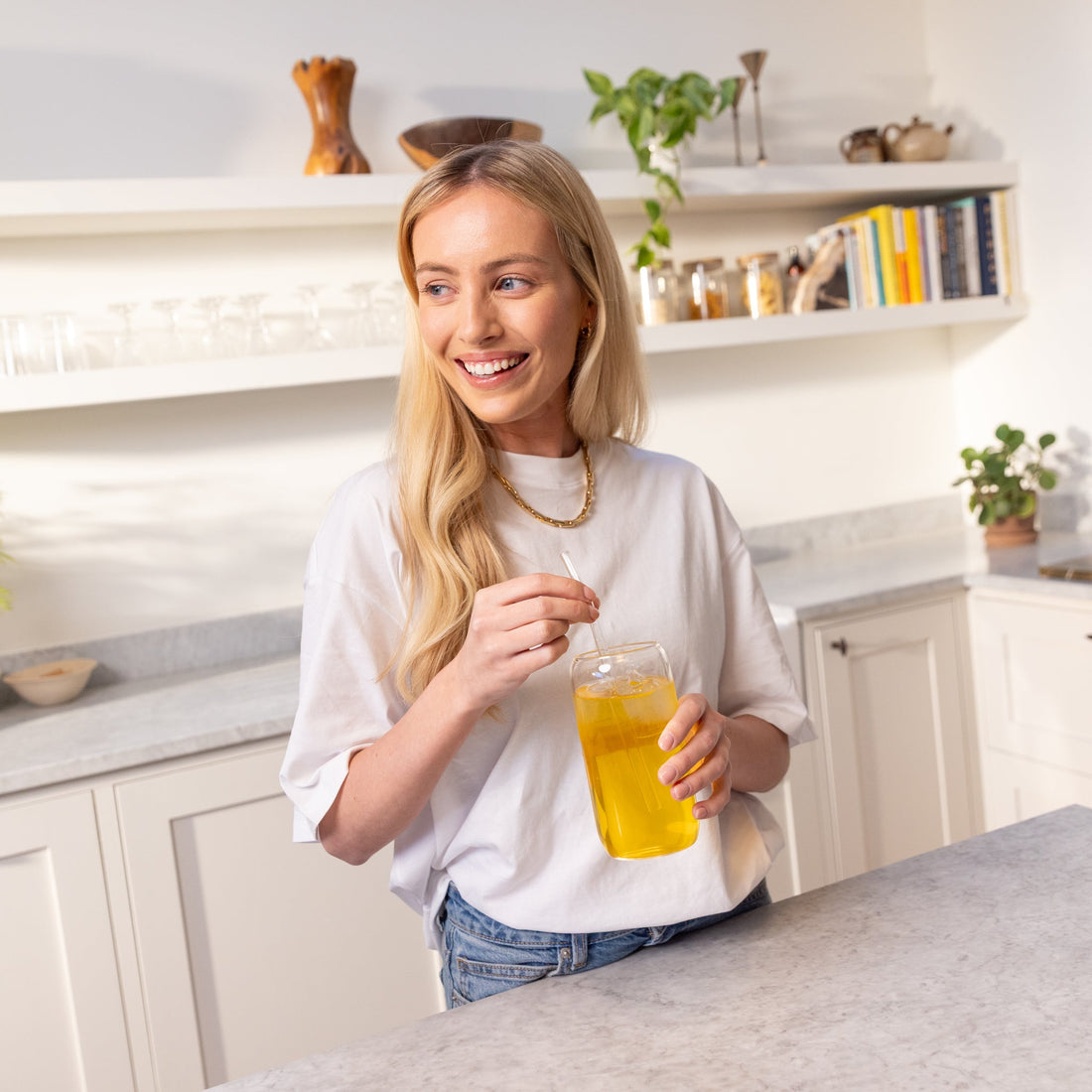 Woman in a kitchen stirring a glass of Herbalife fibre drink