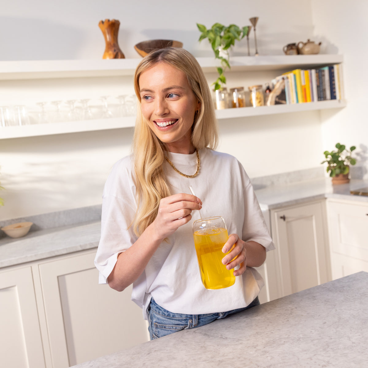 Woman in a kitchen stirring a glass of Herbalife Fibre Concentrate
